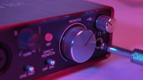 Close-Up of Hand Plugging Headphone Jack into Audio Interface