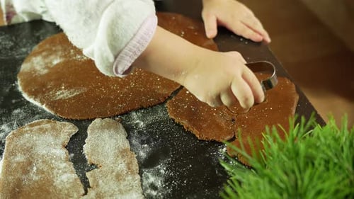 Close-up of little children's hands shaping hearts from gingerbread dough for christmas, holiday fun