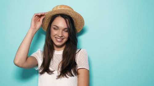 Beautiful woman in hat posing in studio