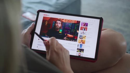 Caucasian Woman Watches Video Blog About Stock Trading Using Tablet Computer