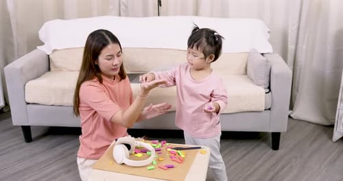 Woman and Child Playing with Colorful Clay Indoors