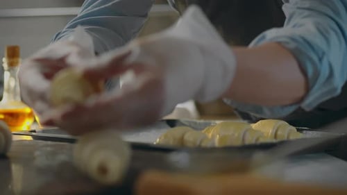 Pastry. In new type of bakery, baker in an apron painstakingly creates fragrant buns. A young