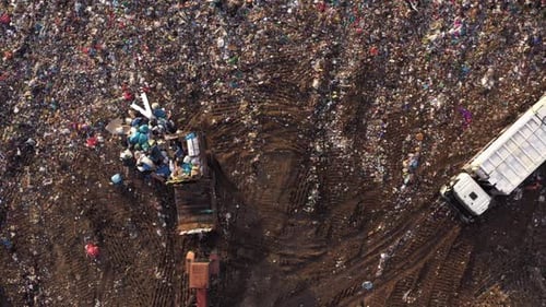 Top View of Tractor Dumps Garbage on the Landfill