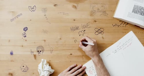 Doodles on Desk With Book and Notebook