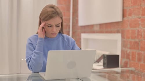 Woman Working on Laptop Massages Temples
