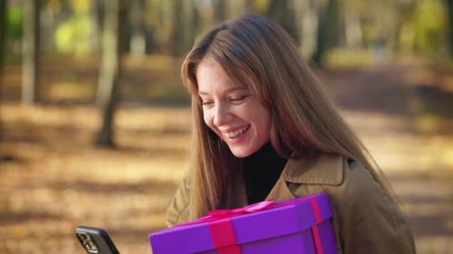 Attractive Young Lady Standing in Park in Sunny Autumn Weather