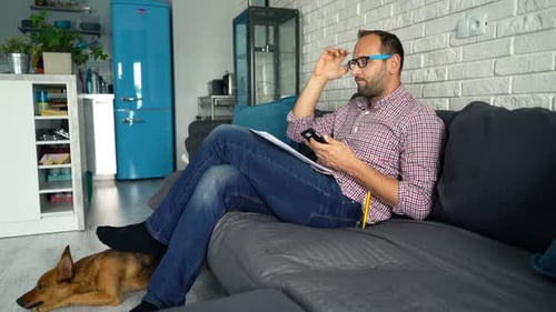 Worried Man Calculates Bills on Phone
