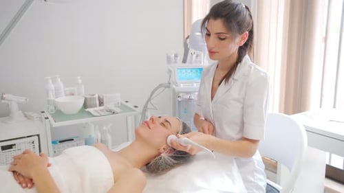 Woman Receiving Facial Treatment in Bright Spa Room