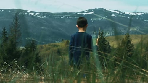 Little boy walking on mountain meadow family hiking adventure in spring day