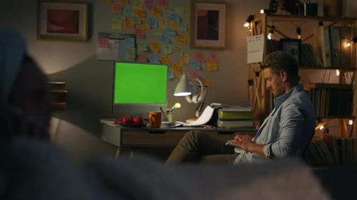 Serious freelancer typing on chromakey computer at night remote work concept