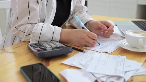 Closeup Hands of Unrecognizable Woman Work at Home in the Kitchen with Financial Papers Counting on