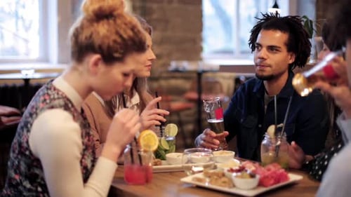 Leisure, Party, People and Holidays Concept - Happy Friends Clinking Drinks At