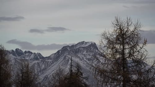 Majestic Mountain Peaks Under a Moving Cloudscape in Winter Timelapse