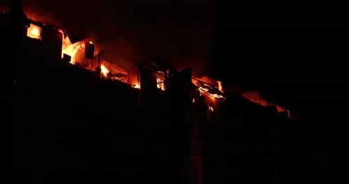 Huge Fire Blazing in Residential Building House is Engulfed in Flames at Night During the Disastrous