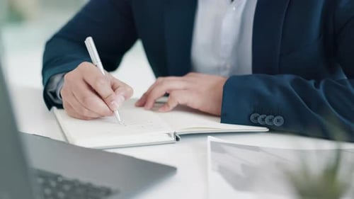 Adult Writing in Notebook at Desk
