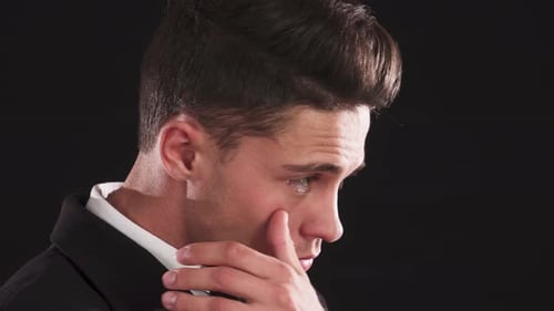 Handsome Man Gently Scratching Under His Eye in a Striking Closeup