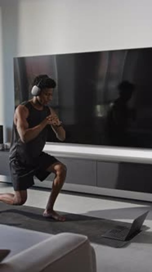 Young Man Exercising at Home on a Yoga Mat