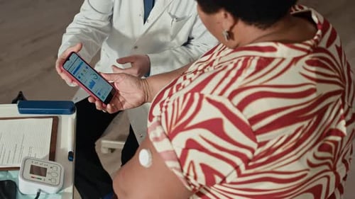 Doctor Showing Glucose Monitor App o Patient
