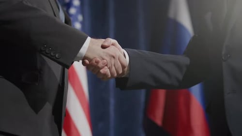 Businessmen Shake Hands In Front Of Country Flags