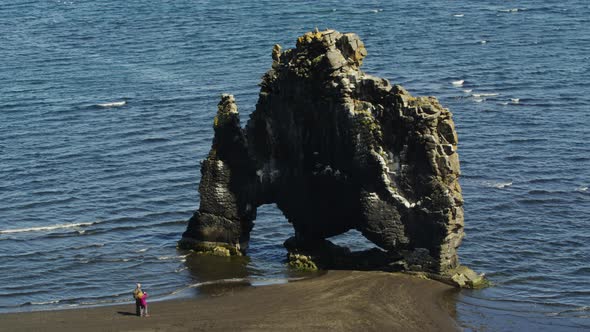 Steady aerial drone view of the Hivitserkur Basalt Sea Stack in Iceland ...