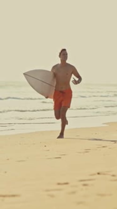 Surfer Running on Beach with Surfboard
