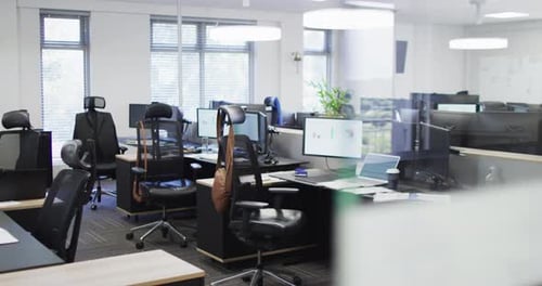 General view of empty modern office with multiple computers, slow motion