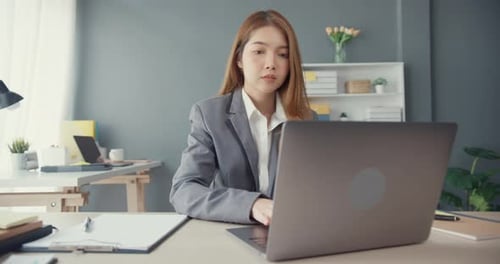 Asia businesswomen using laptop on table working and communicate sitting on office desk.