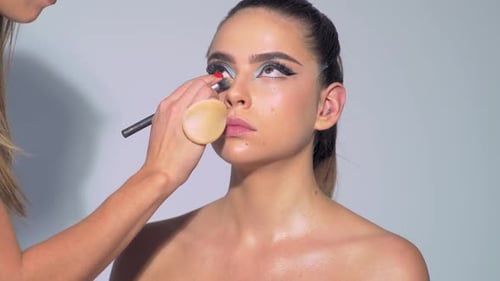 Woman Having Makeup Applied in Studio