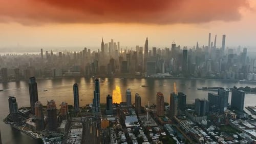 Site of Manhattan in haze over the river. Drone footage above the densely built New York at sunset.