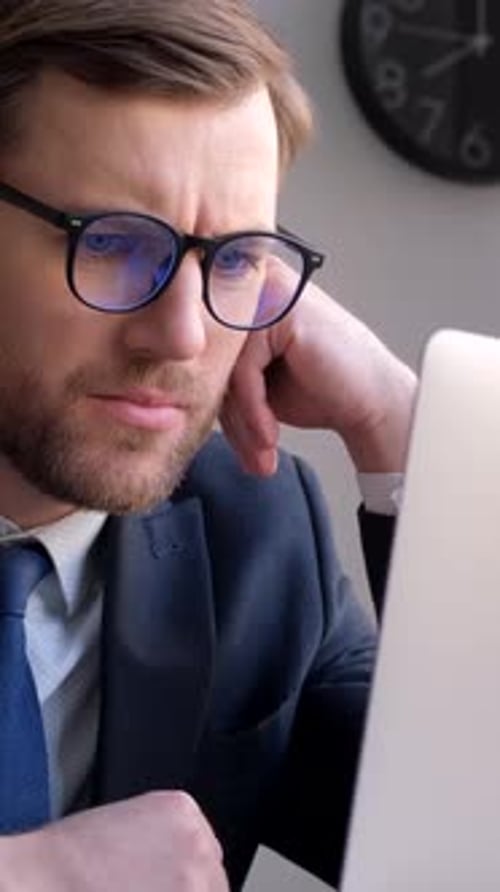 A Young Businessman Works with a Laptop in the Office Vertical Video