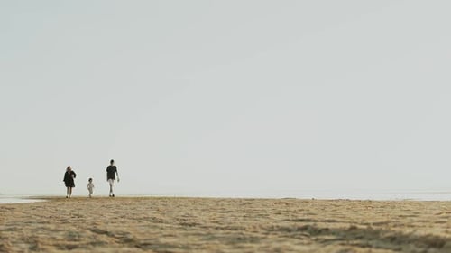 A Family Enjoying a Leisurely Stroll Along a Serene and Beautiful Beach Together