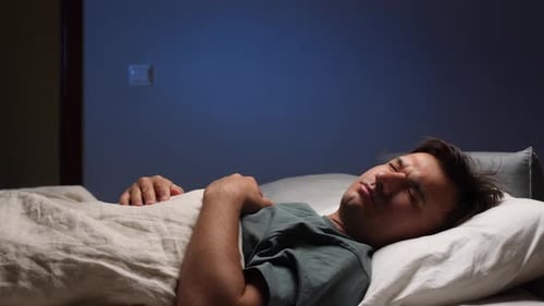 Man Sleeping in Bed with Dark Brown Hair