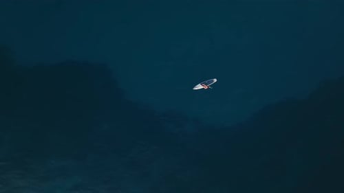 A Man Swims on a SUP Surf in the Open Sea Aerial View 4 K