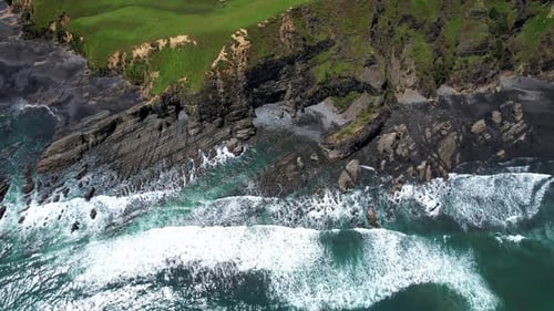Waves crashing on rocky New Zealand shoreline