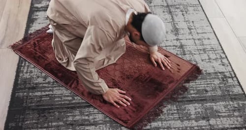 Man Kneels on Prayer Rug Performing Religious Ritual