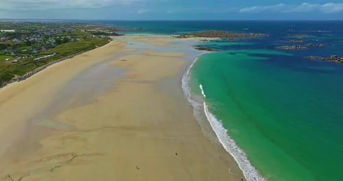 Aerial View of the Tranquil Beach at Plage Des Amiets with Clear Turquoise Water and Waves