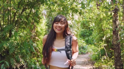 Asian young beautiful woman backpacker traveling alone in forest wild.