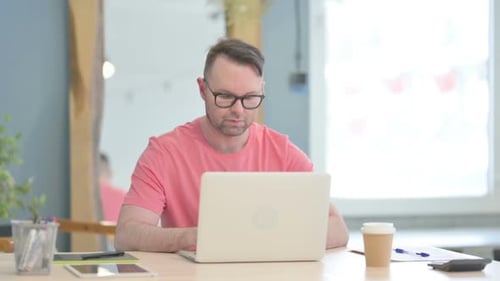 Mann verlässt das Büro, nachdem er den Laptop geschlossen hat