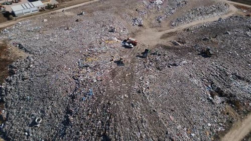 Aerial View of a Vast Landfill Where Bulldozers are Working and Trucks are Bringing New Waste Huge