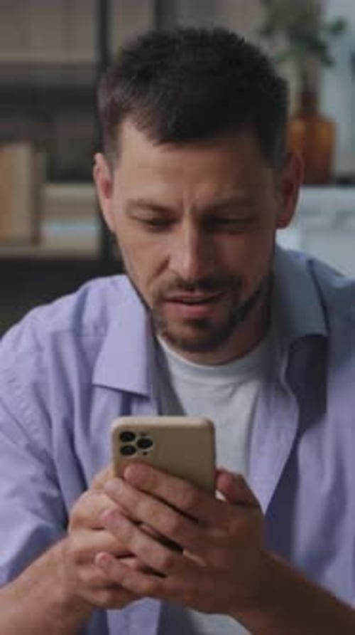 Smiling Man Using Smartphone Inside Modern Home