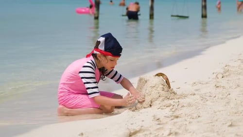 Little Girl in Swimsuit Playing on Beach