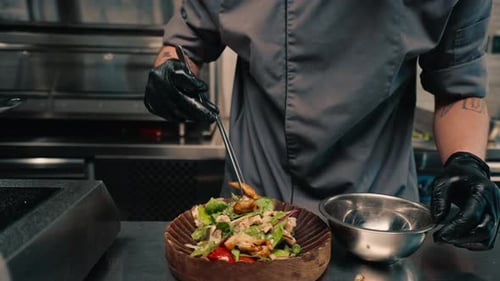 The chef of the restaurant serves freshly prepared salad with chicken on a plate Asian cuisine