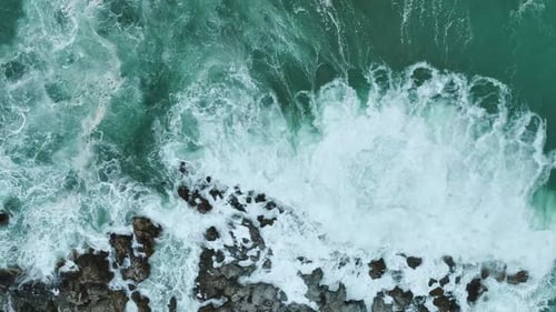 Aerial Video of Rugged Shoreline With White Spray Turquoise Water and Waves Crashing Along Rocks