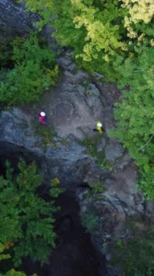 Aerial View Young Couple of Hikers Reaching Mountain Top Hugging and Rejoicing Successful Climbing