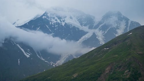Scenic Snow-Capped Mountains Under Cloudy Sky