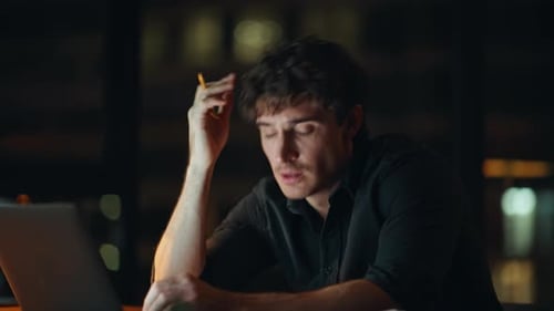 Overworked Employee Unmotivated Work Overtime at Dark Agency Workplace Closeup