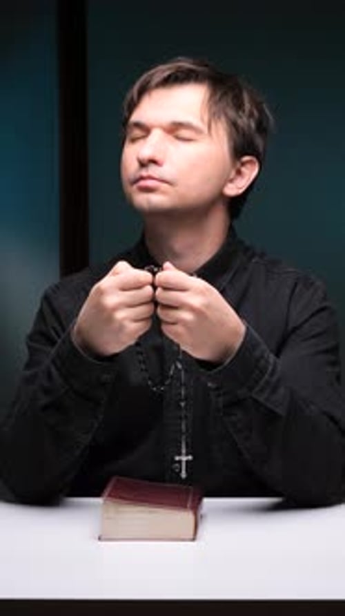 Man Praying with Rosary Beads and Closed Eyes