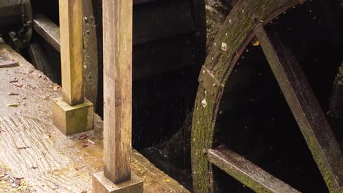 Close up on the bottom section of two hydraulic wheels from a water mill. Camera on the shaft level