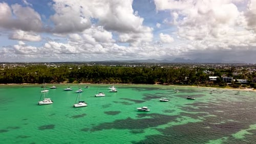 Aerial View of Many Yachts and Catamarans Anchored in a Stunning Turquoise Bay on a Summer Day