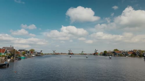Panoramic wide shot of the iconic windmills and traditional Dutch houses along the Zaan river at